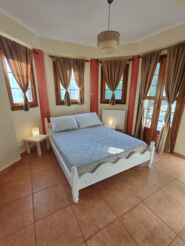 a bedroom with a bed with red walls and windows at Perdika Beige in Pérdika
