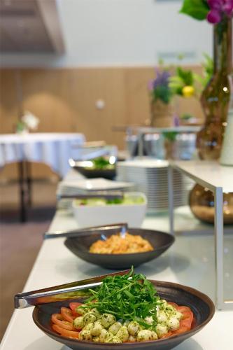 a buffet with two plates of food on a table at Radisson Blu Hotel, Lucerne in Luzern