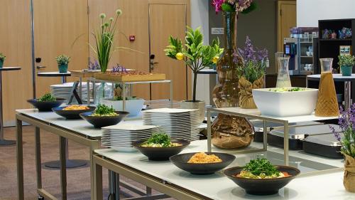 a table with bowls and plates and plants on it at Radisson Blu Hotel, Lucerne in Luzern