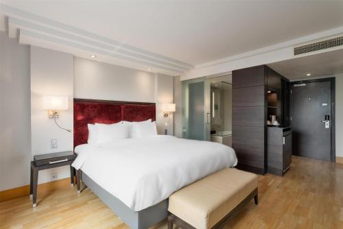 a bedroom with a large white bed with a red headboard at Radisson Blu Elizabete Hotel, Riga in Rīga