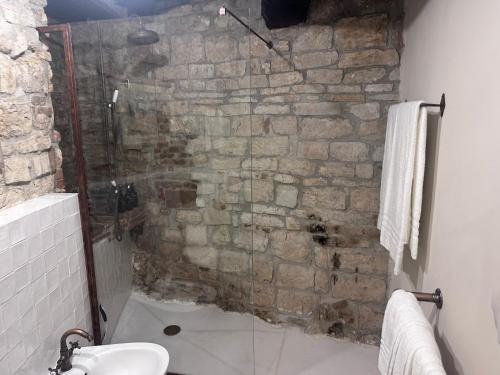 a bathroom with a stone wall and a shower at Nido di Gufi in Todi