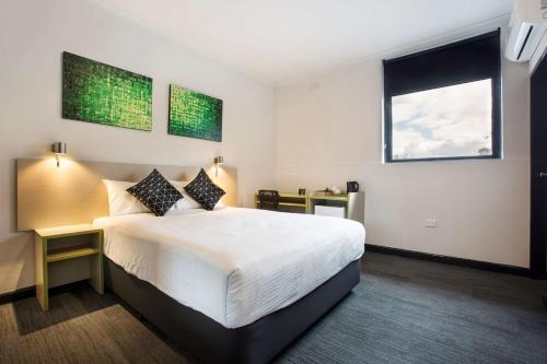 a hotel room with a large bed and a window at Nightcap at St Albans Hotel in St Albans