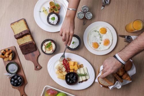 a table with plates of breakfast food on it at Radisson Hotel & Residence Riyadh Olaya in Riyadh