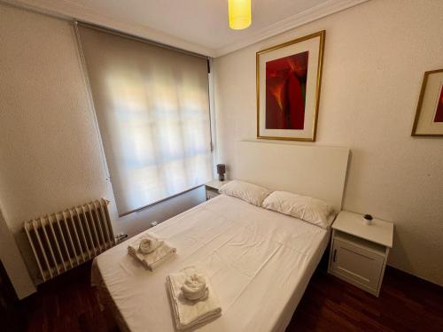 ein kleines Zimmer mit einem Bett mit zwei Handtüchern darauf in der Unterkunft Apartamento Reyes de España / Free Parking & Wi Fi in Salamanca