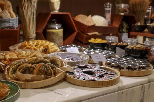 a table filled with different types of bread and pastries at Radisson Hotel & Residence Riyadh Olaya in Riyadh