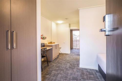 an open door to a room with a kitchen at Nightcap at Shoppingtown Hotel in Doncaster