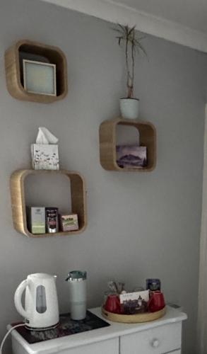 a kitchen with wooden shelves and a mirror on the wall at Edinburgh Home from Home in EDI
