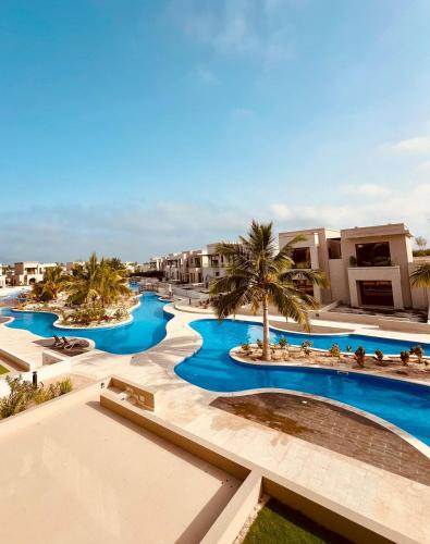 an aerial view of a resort with blue pools at Dream Apartment - Near Beach with Pool View & WiFi in Salalah