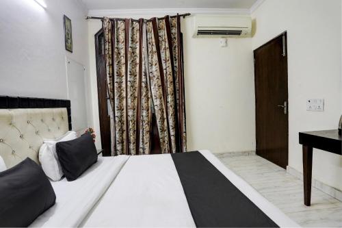 a bedroom with a bed and a desk and a window at Hotel O Metro Residency in New Delhi