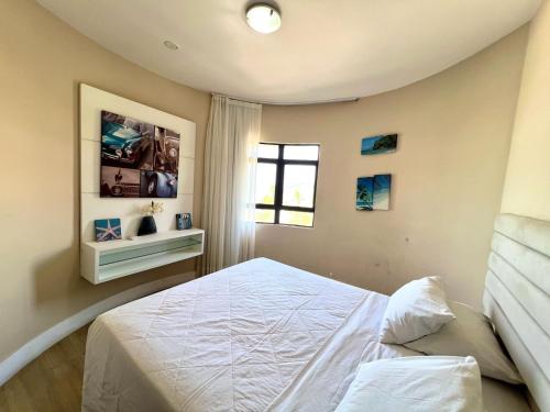 a bedroom with a white bed and a window at Elegance Comfort Natal Beira Mar in Natal