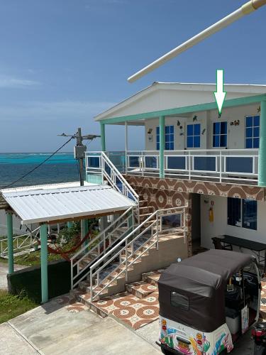 a building on the beach with a military statue next to it at Posada Three Cay Suites in Providencia