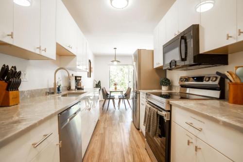 a kitchen with white cabinets and stainless steel appliances at Stylish Bellevue Stay half mile to downtown in Bellevue
