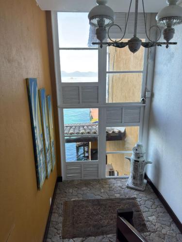 a room with a window with a view of the ocean at Pousada Casa do Bicho Preguiça in Angra dos Reis