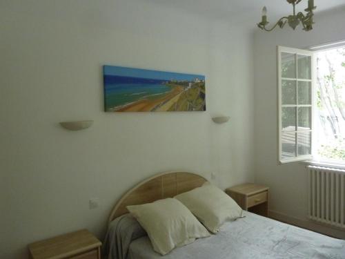 une chambre avec un lit et un tableau au mur dans l'établissement Maison dans un écrin de verdure, à Biarritz
