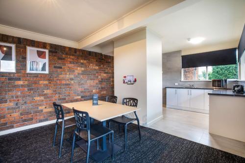 a kitchen and dining room with a brick wall at Nightcap at Manhattan Hotel in Ringwood