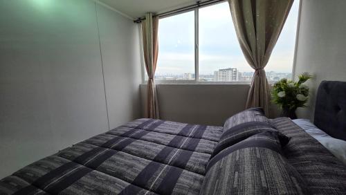 une chambre avec un lit et une grande fenêtre dans l'établissement Oceana Suites Independencia, à Santiago