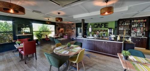 a restaurant with tables and chairs and a bar at Hôtel Cap Sud Avignon - Réouverture - Ex Kyriad Hôtel in Avignon