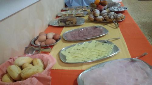 una mesa cubierta con platos de comida, huevos y pan en Hotel Pigalle, en Rímini