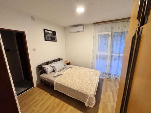 a small bedroom with a bed and a window at Mon in Bar