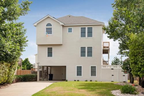a large white house with a garage at Weekend at Pinchys in Kill Devil Hills