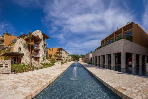 a building with a fountain in front of a building at Hotel Xcaret Mexico All Parks All Fun Inclusive in Playa del Carmen