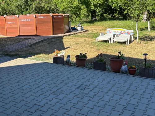 a patio with potted plants and a table and a tent at Pensiunea Anca Sapanta-primeste carduri de vacanta in Săpînţa