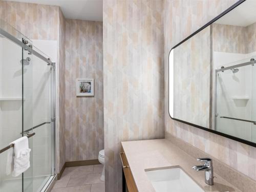 a bathroom with a sink and a shower at Hampton Inn St Ignace Lakefront Mackinac in Evergreen Shores