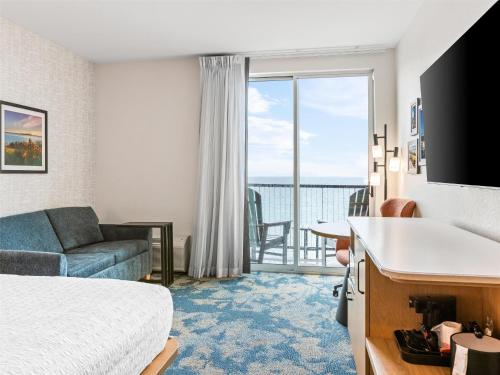 a hotel room with a bed and a view of the ocean at Hampton Inn St Ignace Lakefront Mackinac in Evergreen Shores