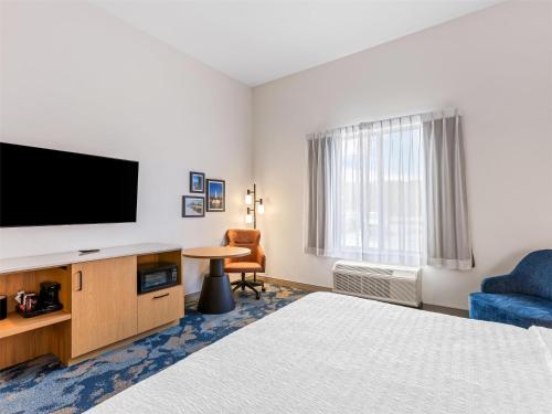 a hotel room with a bed and a flat screen tv at Hampton Inn St Ignace Lakefront Mackinac in Evergreen Shores