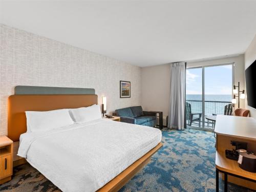 a hotel room with a bed and a view of the ocean at Hampton Inn St Ignace Lakefront Mackinac in Evergreen Shores