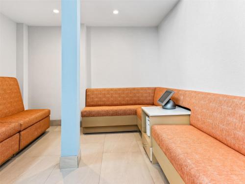 a waiting room with two orange couches and a table at Hampton Inn St Ignace Lakefront Mackinac in Evergreen Shores