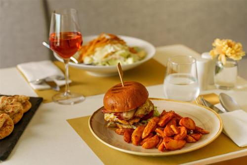 a table with a sandwich and a plate of fries at Radisson Resort Plaza Skiathos in Kanapitsa