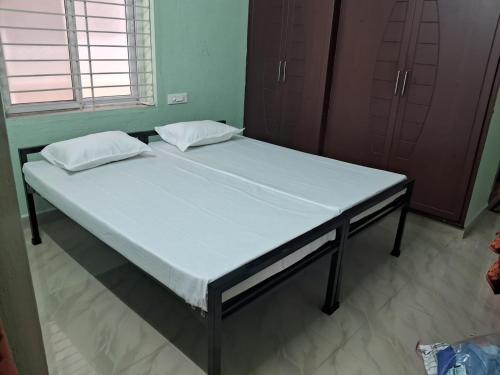 a bed in a room with two pillows on it at Meraki Home in Vijayawāda