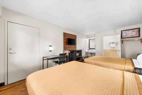 a hotel room with two beds and a desk at Econo Lodge Charlotte Airport in Charlotte