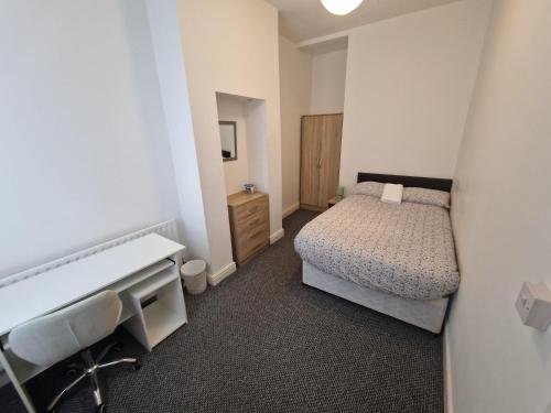 a small bedroom with a bed and a sink at David Guest House in Stoke on Trent