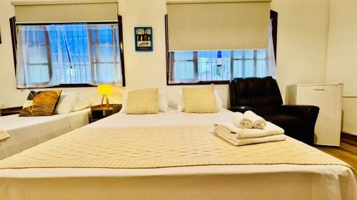 a bedroom with a bed with two towels on it at Pousada Petit Refuge in Juquei