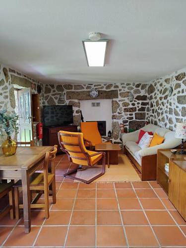 a living room with a stone wall at Casa do Costeiro by AlmaStay in Gondufe