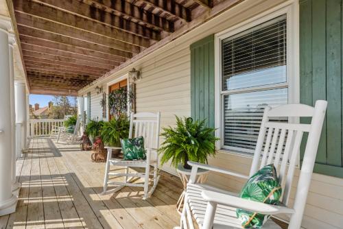a porch with white rocking chairs and a window at Worthington Lane in Kitty Hawk