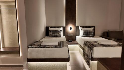 two beds in a small room with a mirror at PALEMON Resort& Spa in Manavgat