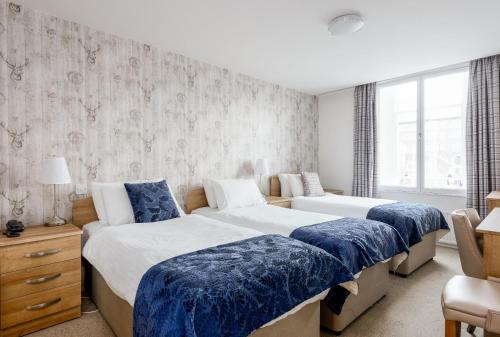 a bedroom with two beds with blue blankets at The Lakeland Kendal Hotel, Sure Hotel Collection by Best Western in Kendal