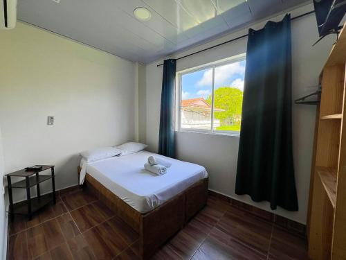 a small bedroom with a bed and a window at Sukha Hippocampus San Andrés Isla in San Andrés