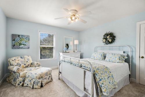 a bedroom with a bed and a ceiling fan and a chair at Worthington Lane in Kitty Hawk