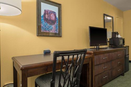 a room with a desk with a computer and a television at Airport Honolulu Hotel, Trademark Collection by Wyndham in Honolulu