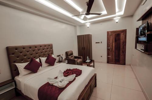 Un dormitorio con una cama grande y una silla. en Lee Rooms, en Nāgercoil