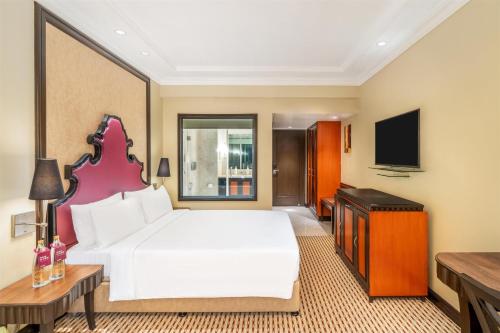 a bedroom with a large white bed and a flat screen tv at St Mark's Hotel Bengaluru, a member of Radisson Individuals in Bengaluru