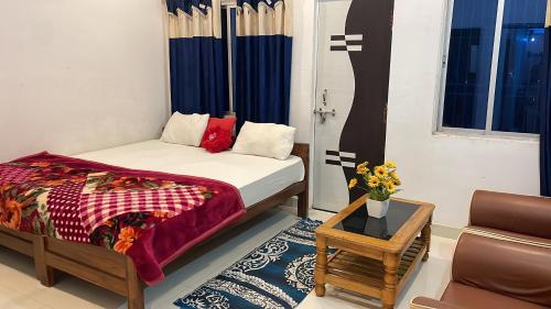 a bedroom with a bed and a couch and a table at Hotel kaushlendra palace in Rājgīr