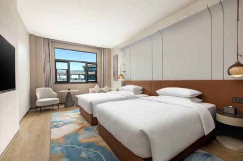eine Reihe von Betten in einem Hotelzimmer in der Unterkunft Wyndham Garden Changsha University Town in Changsha
