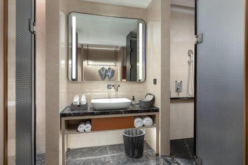 ein Badezimmer mit Waschbecken und Spiegel in der Unterkunft Wyndham Garden Changsha University Town in Changsha
