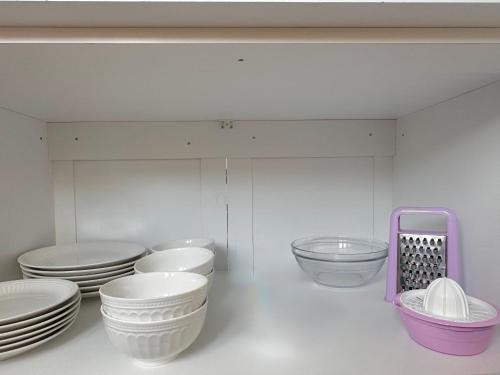 a bunch of bowls and plates on a shelf at PROMO Elegant Apartments NEW - Colorful by the sea in Durrës