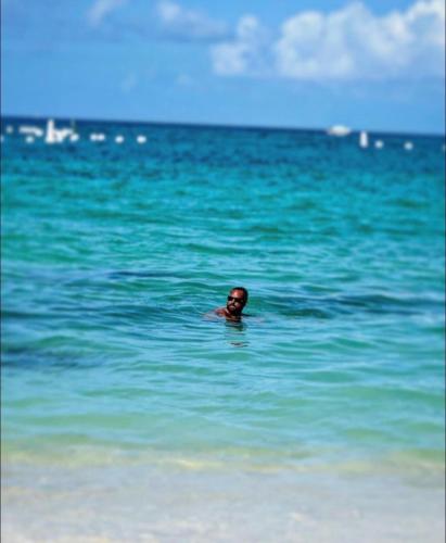 a man swimming in the ocean on the beach at Hostel bunker Peruano in Playa Blanca